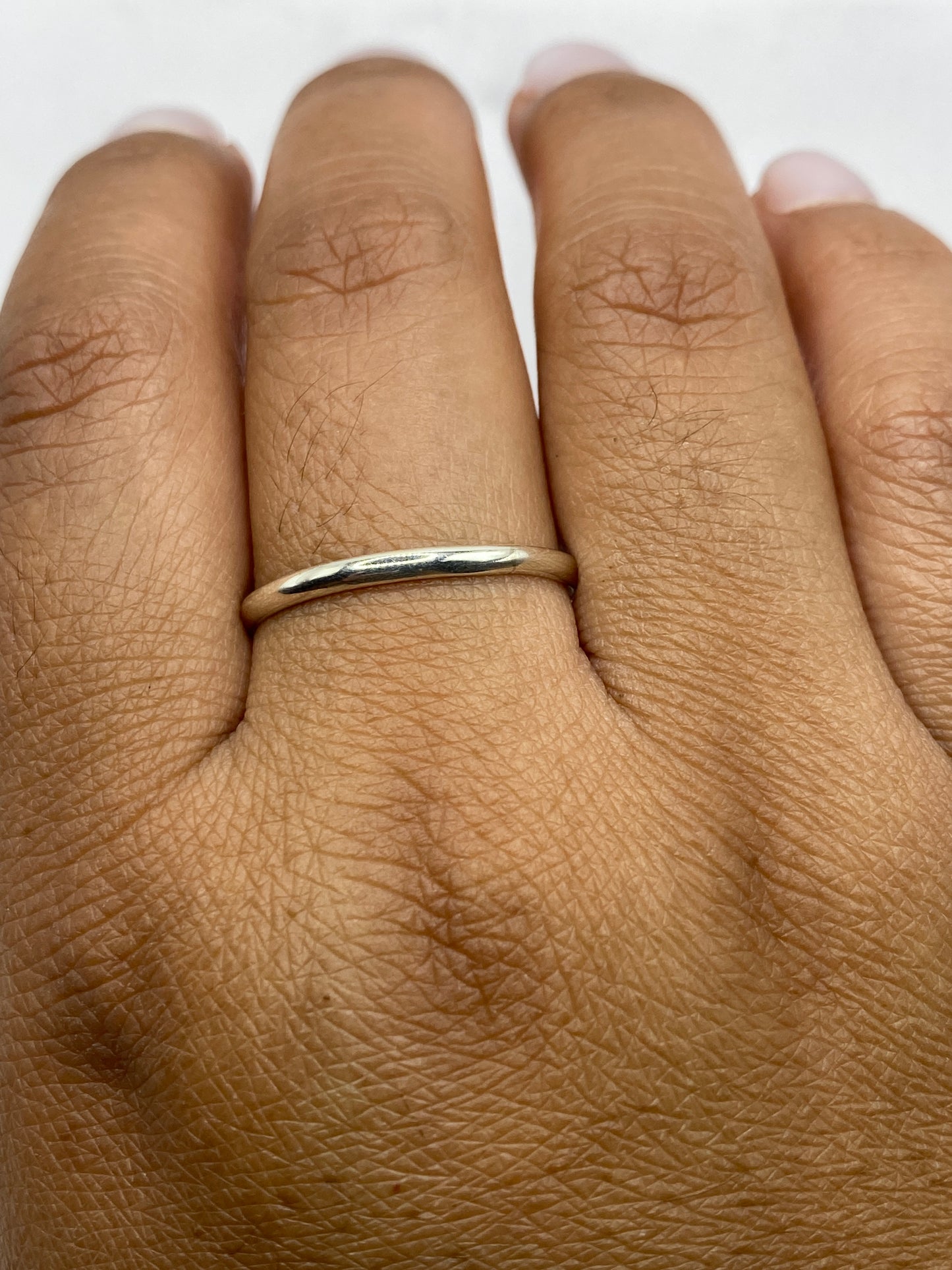 Anillo de banda plata sobre fondo blanco con sello .925 visible