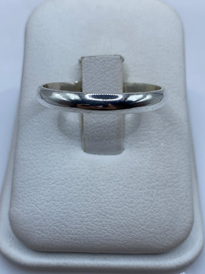 Anillo de plata banda pulida minimalista en estuche blanco mostrando el brillo espejo