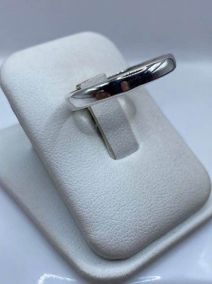 Anillo minimalista de plata pura visto desde el lateral con acabado espejo