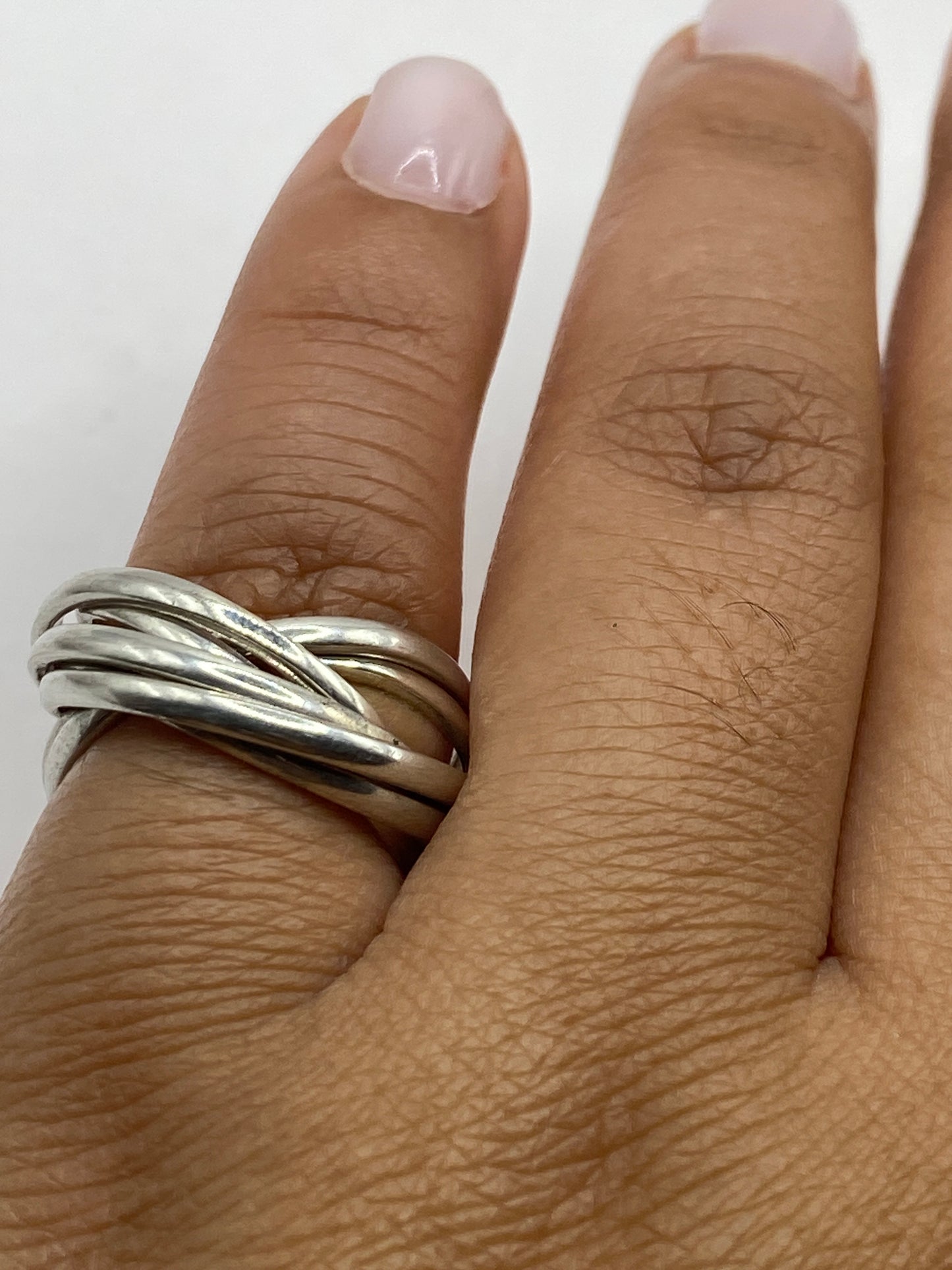 Anillo de eslabones sobre fondo gris mostrando el acabado minimalista