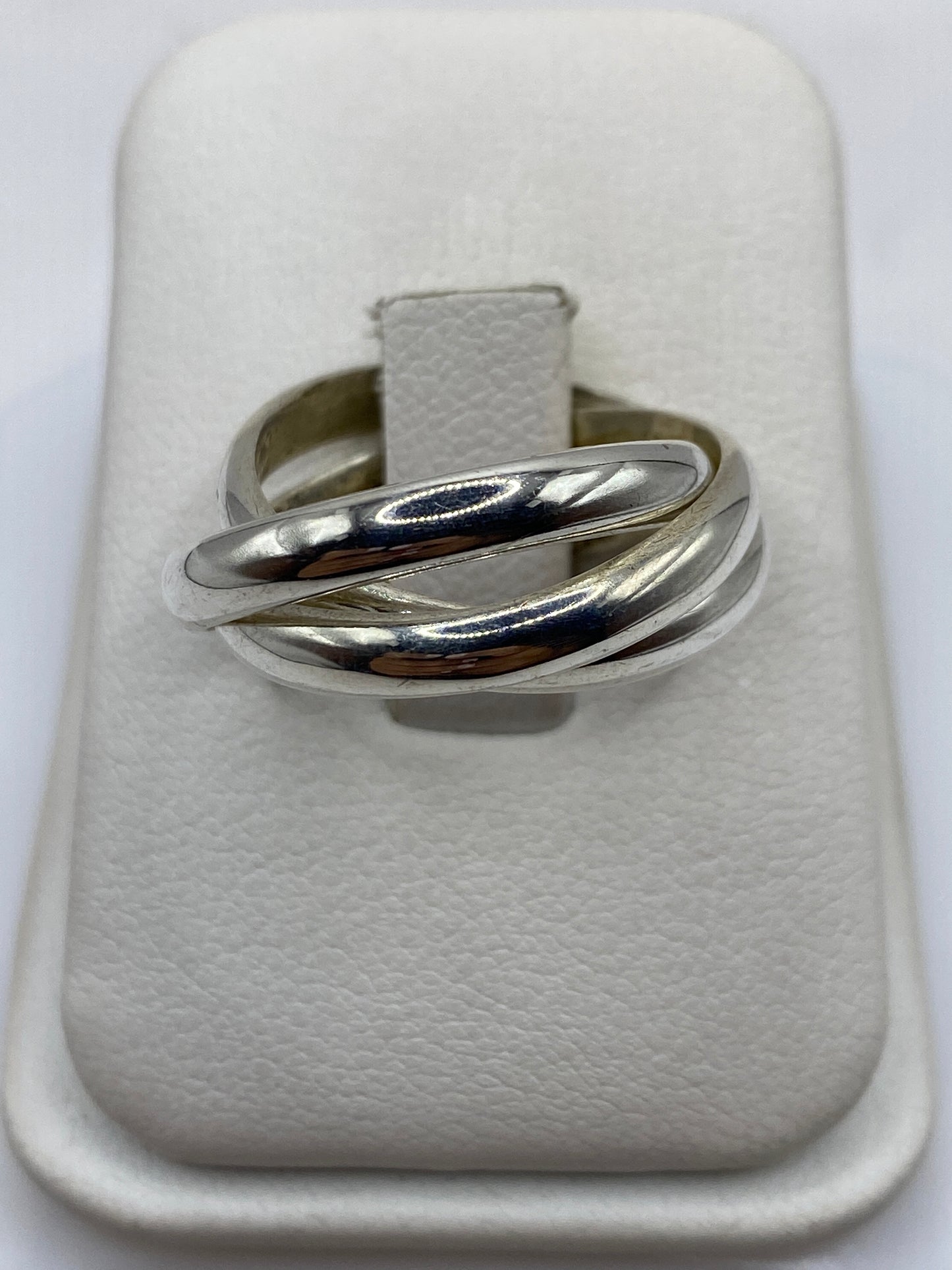 Anillo de plata entrelazado con tres bandas pulidas en mano femenina