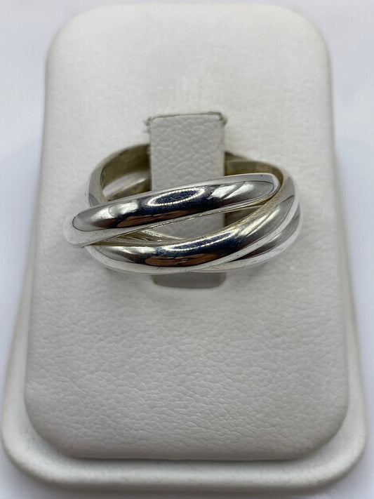 Anillo de plata entrelazado con tres bandas pulidas en mano femenina