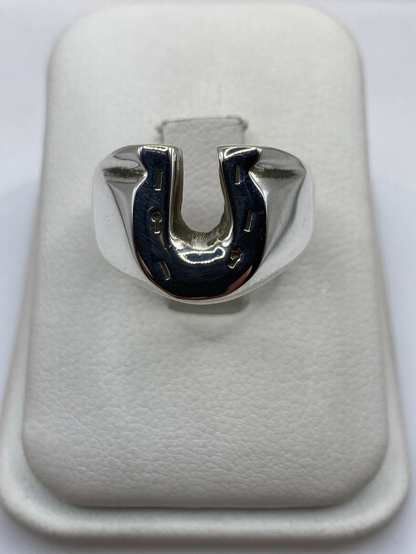 Anillo herradura de plata .925 maciza en la mano de un hombre, frente brilla