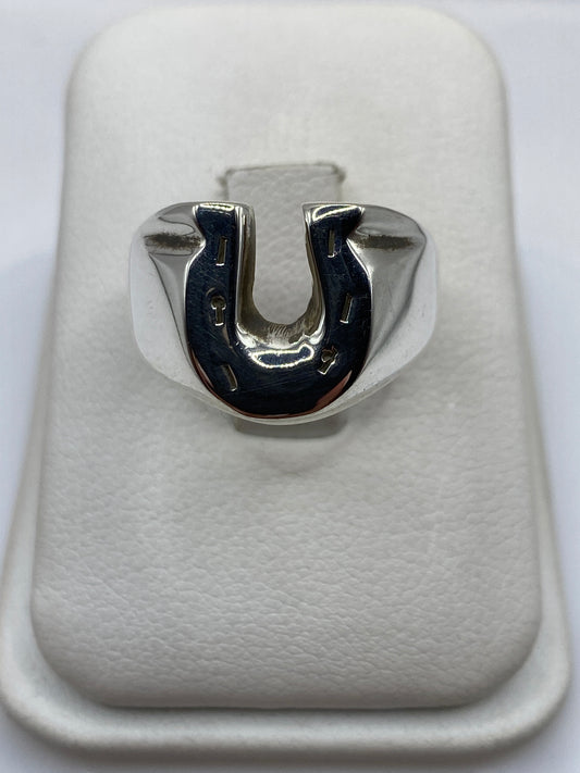 Anillo herradura de plata .925 maciza en la mano de un hombre, frente brilla