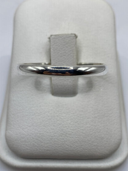 Anillo de plata pulida minimalista en mano de hombre mostrando el acabado espejo