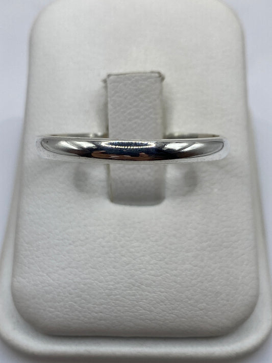 Anillo de plata pulida minimalista en mano de hombre mostrando el acabado espejo