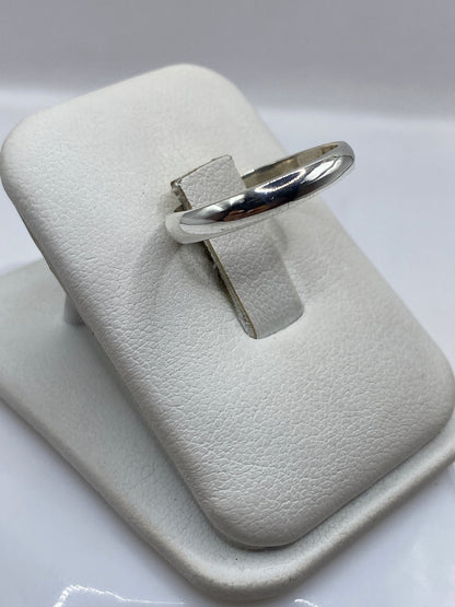 Anillo minimalista de plata en la mano, mostrando brillo espejo