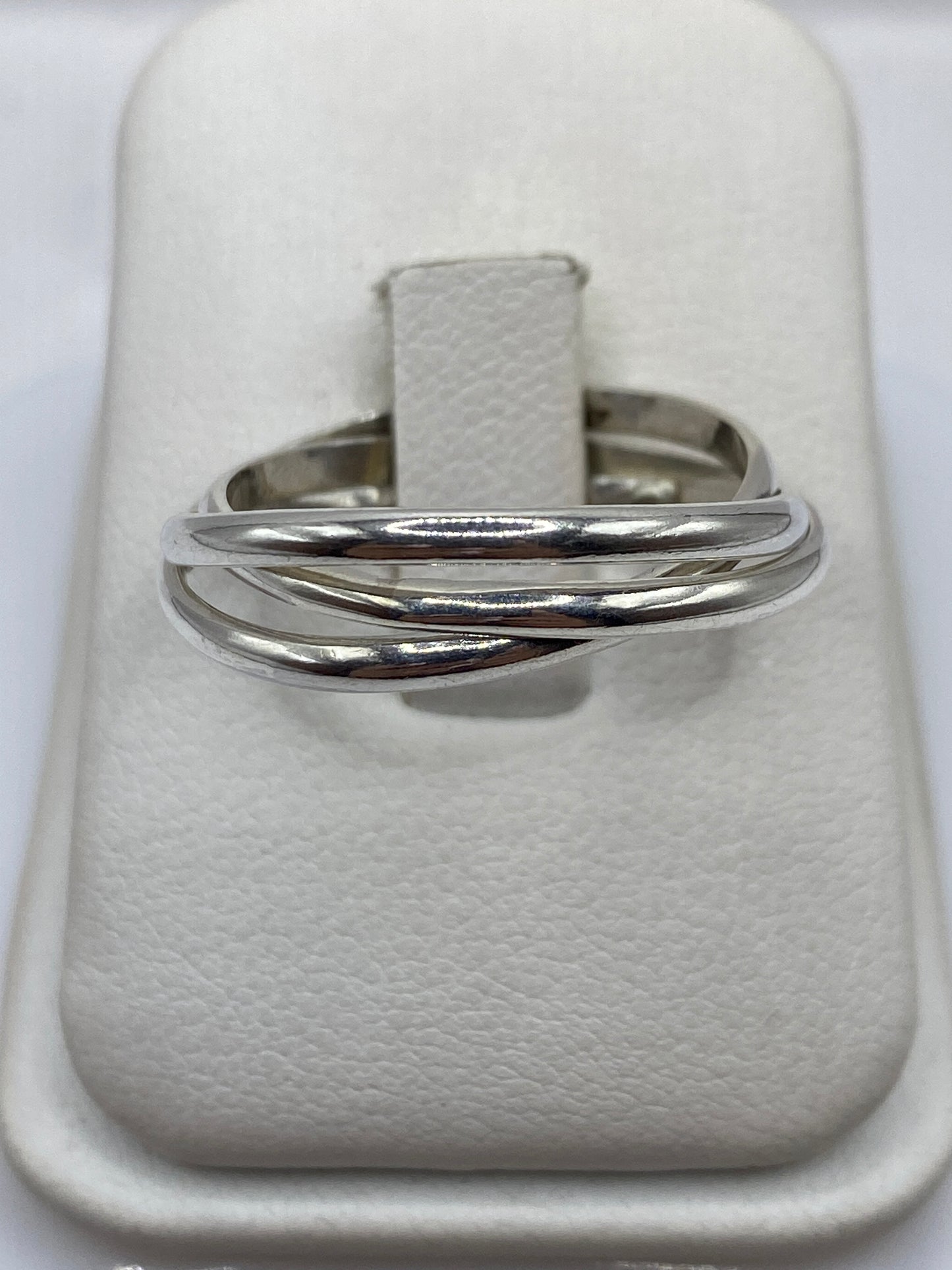 Anillo de plata banda pulida minimalista en la mano de una mujer