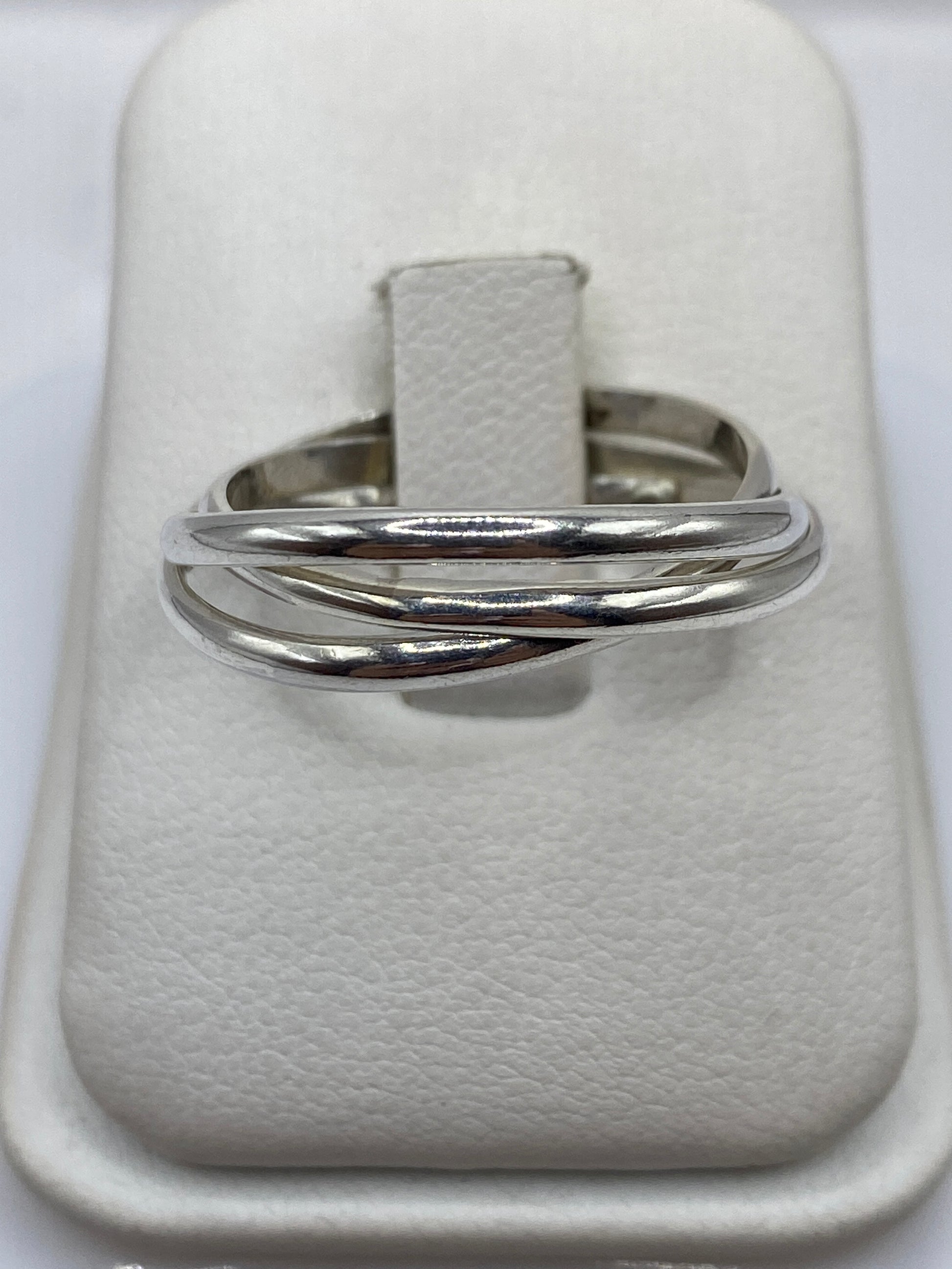 Anillo de plata banda pulida minimalista en la mano de una mujer