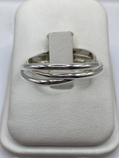 Anillo de plata banda pulida minimalista en la mano de una mujer