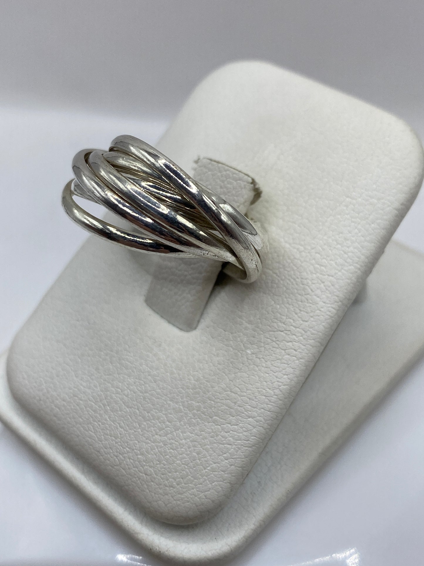 Detalle del anillo de triple banda entrelazada en plata .925, pulido espejo