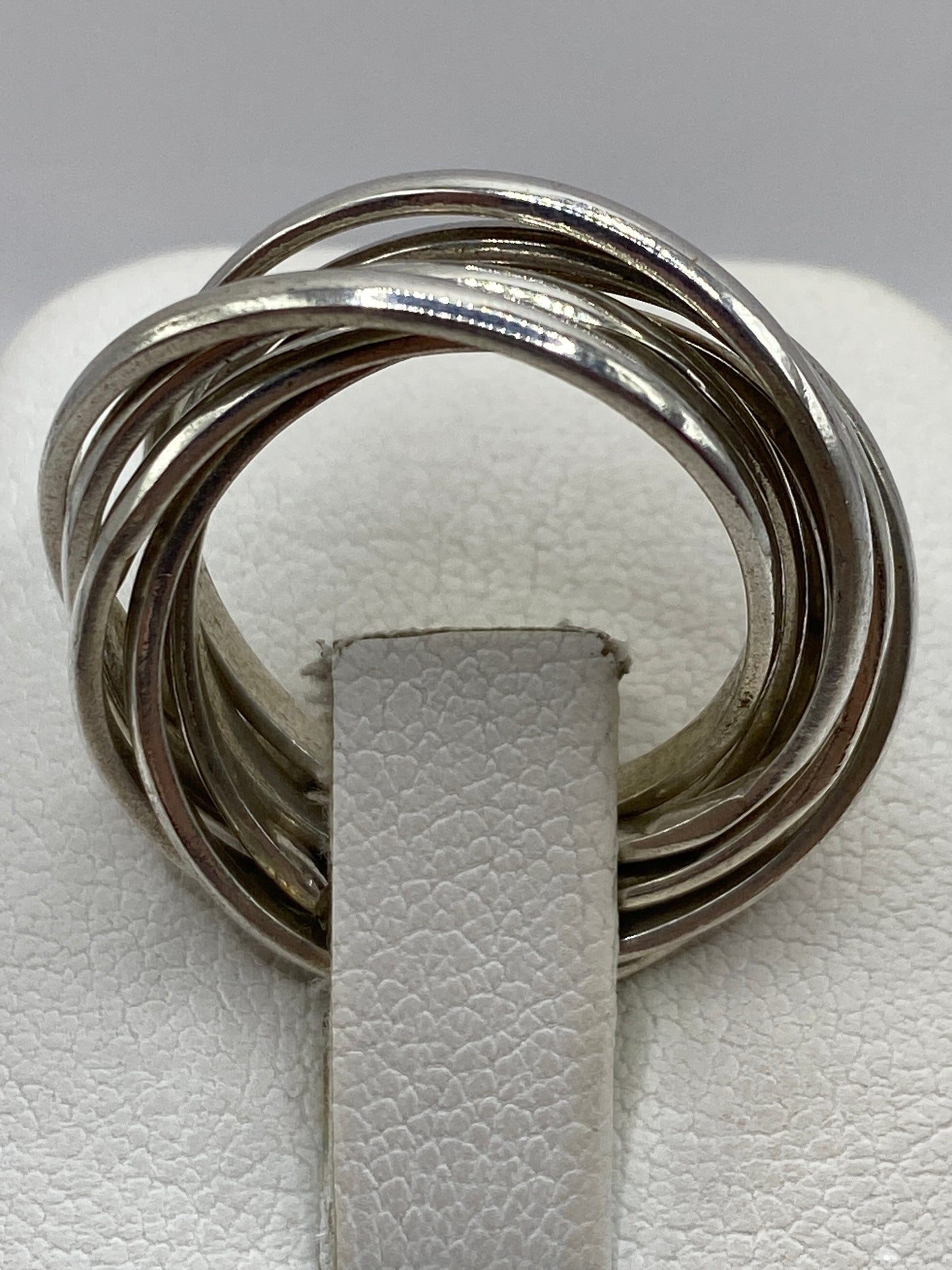 Anillo de plata en la mano mostrando el acabado brillante y el movimiento de las bandas