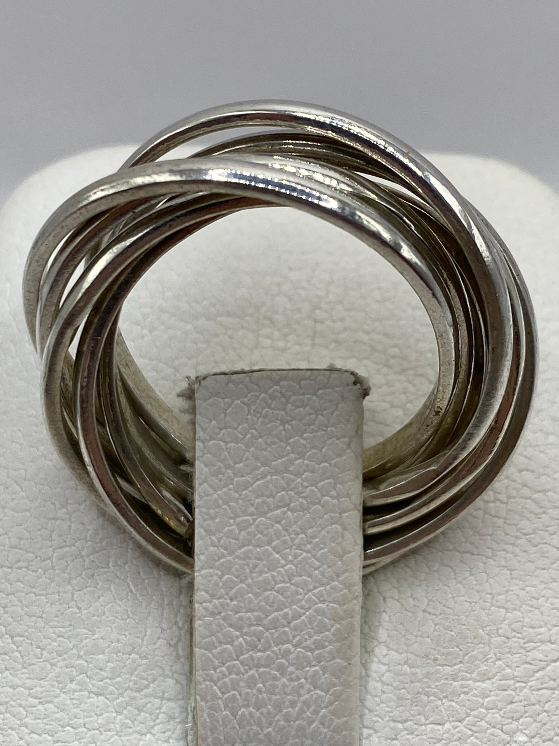 Anillo de plata en la mano mostrando el acabado brillante y el movimiento de las bandas