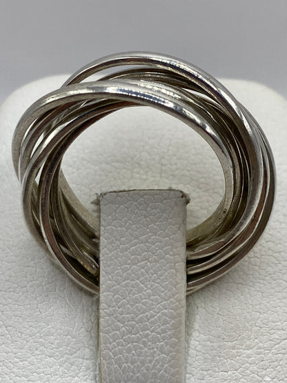 Anillo de plata en la mano mostrando el acabado brillante y el movimiento de las bandas
