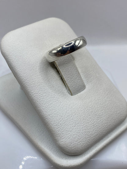 Detalle lateral del anillo minimalista mostrando el pulido espejo en plata