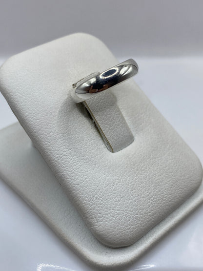 Anillo minimalista de plata en dedo de mujer, mostrando el pulido espejo