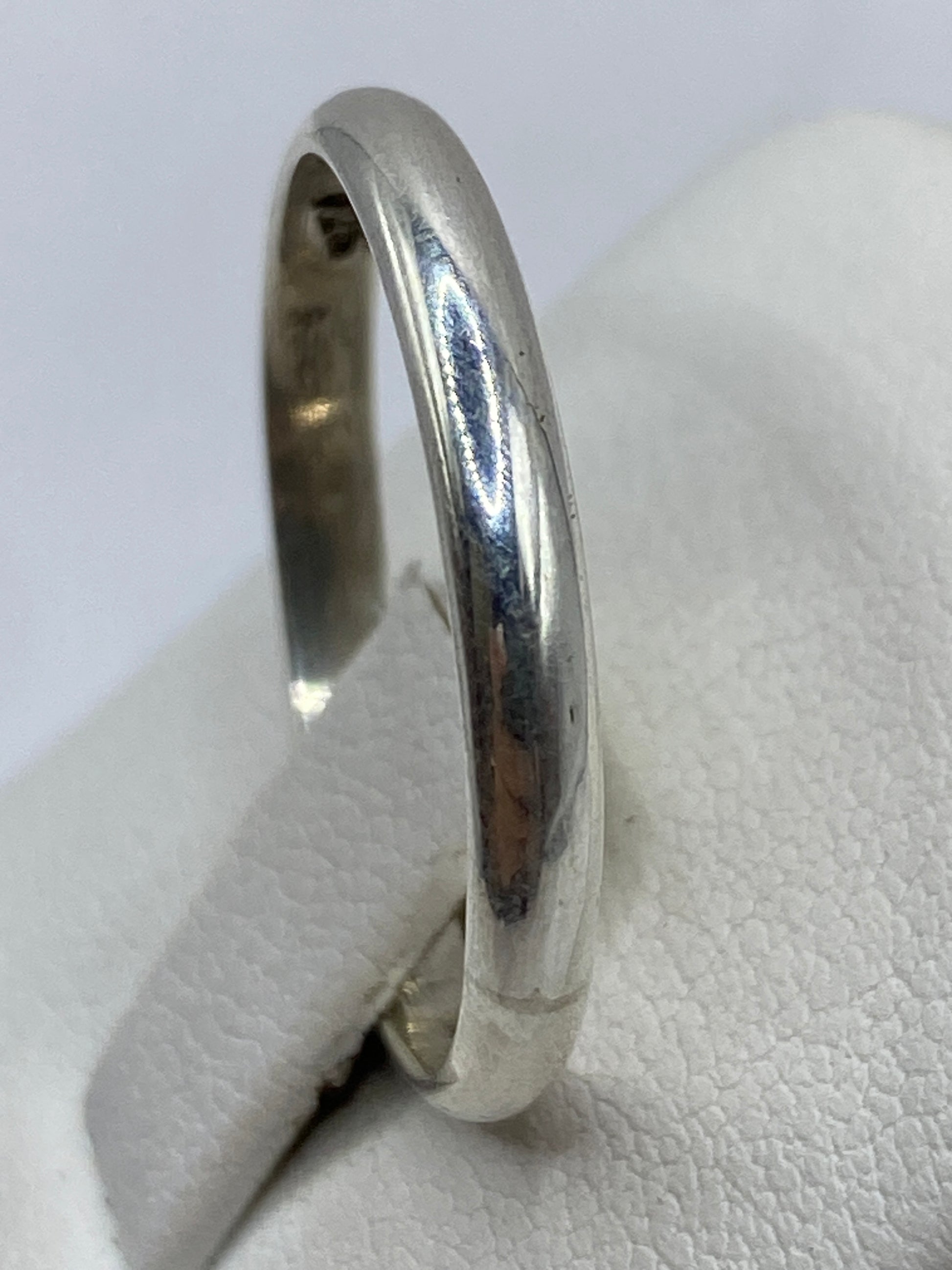 Anillo banda sobre fondo blanco mostrando el acabado brillante y el sello 925