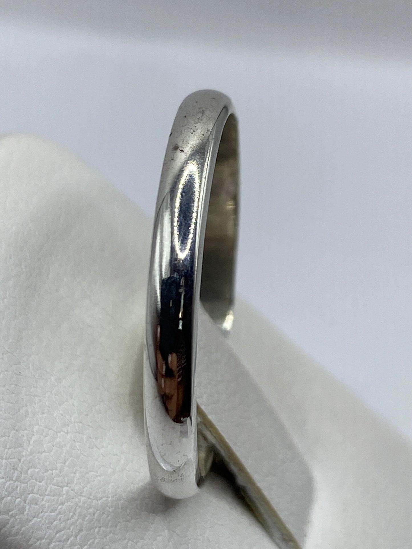 Anillo de plata sobre presentador blanco, talla 13