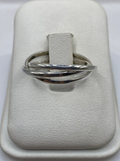 Anillo de plata con tres bandas cruzadas en la mano de una mujer