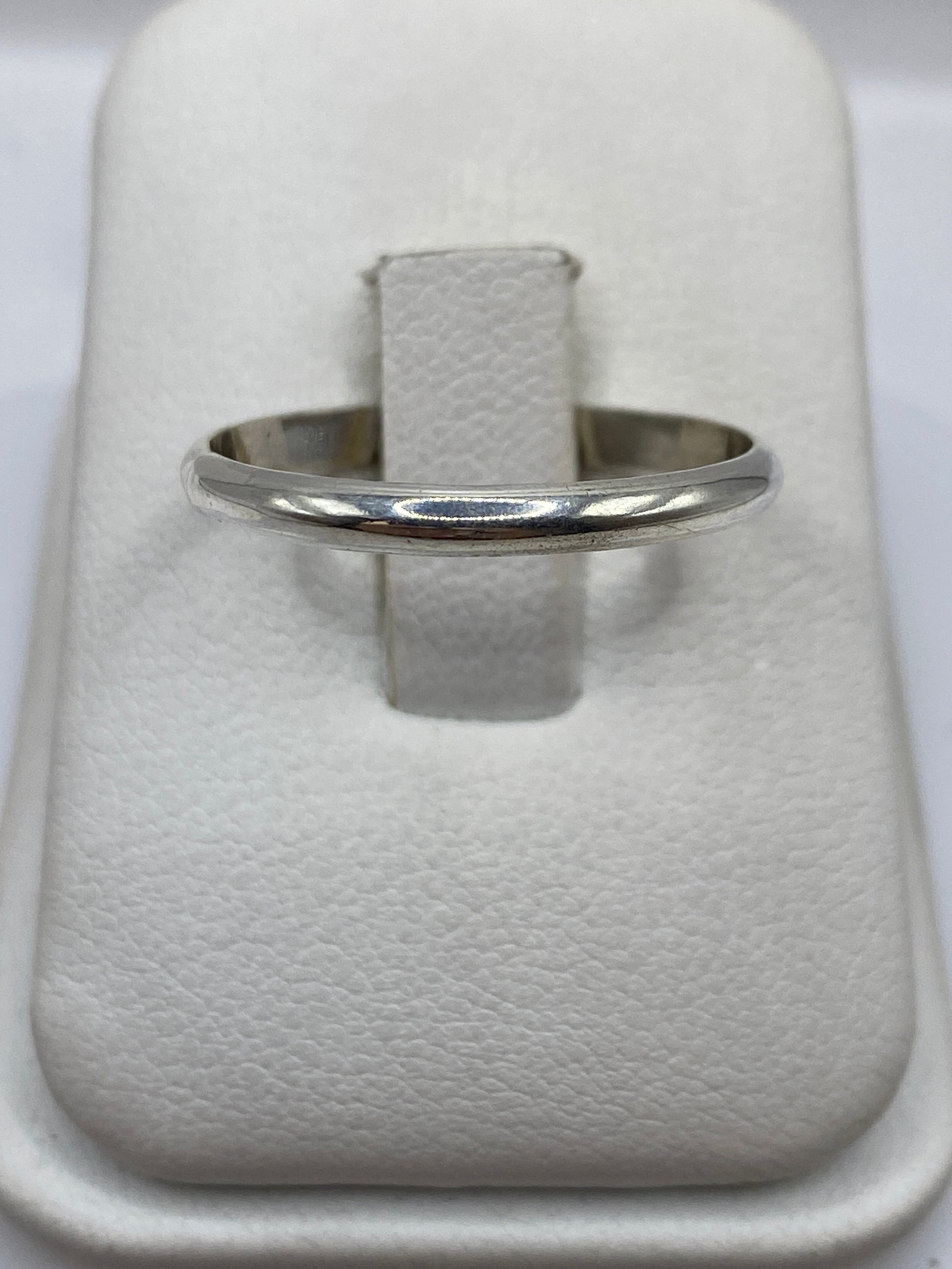 Anillo banda de plata .925 pulido en mano de mujer mostrando el pulido brillante