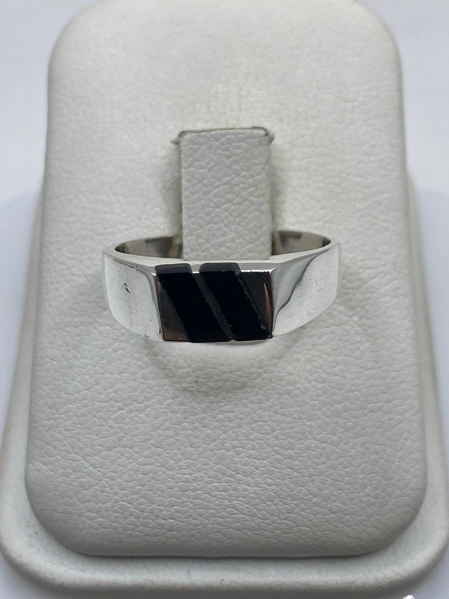 Anillo de onix negro pulido engastado en plata .925, vista frontal sobre la mano