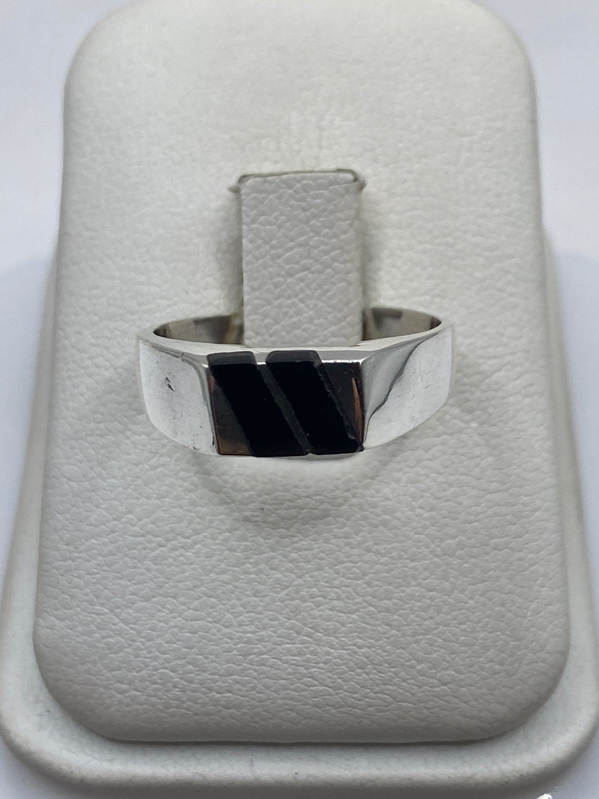 Anillo de onix negro pulido engastado en plata .925, vista frontal sobre la mano