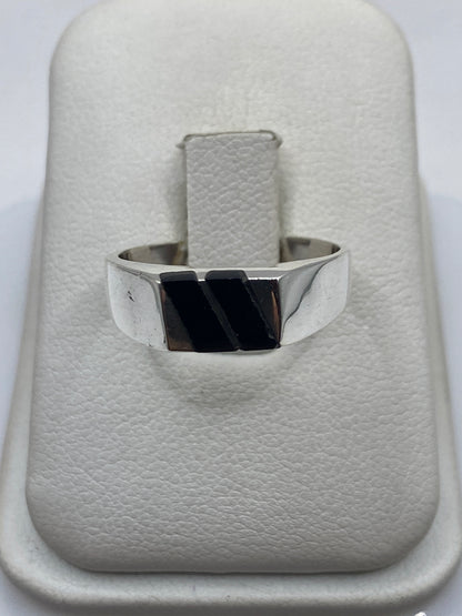 Anillo de onix negro pulido engastado en plata .925, vista frontal sobre la mano