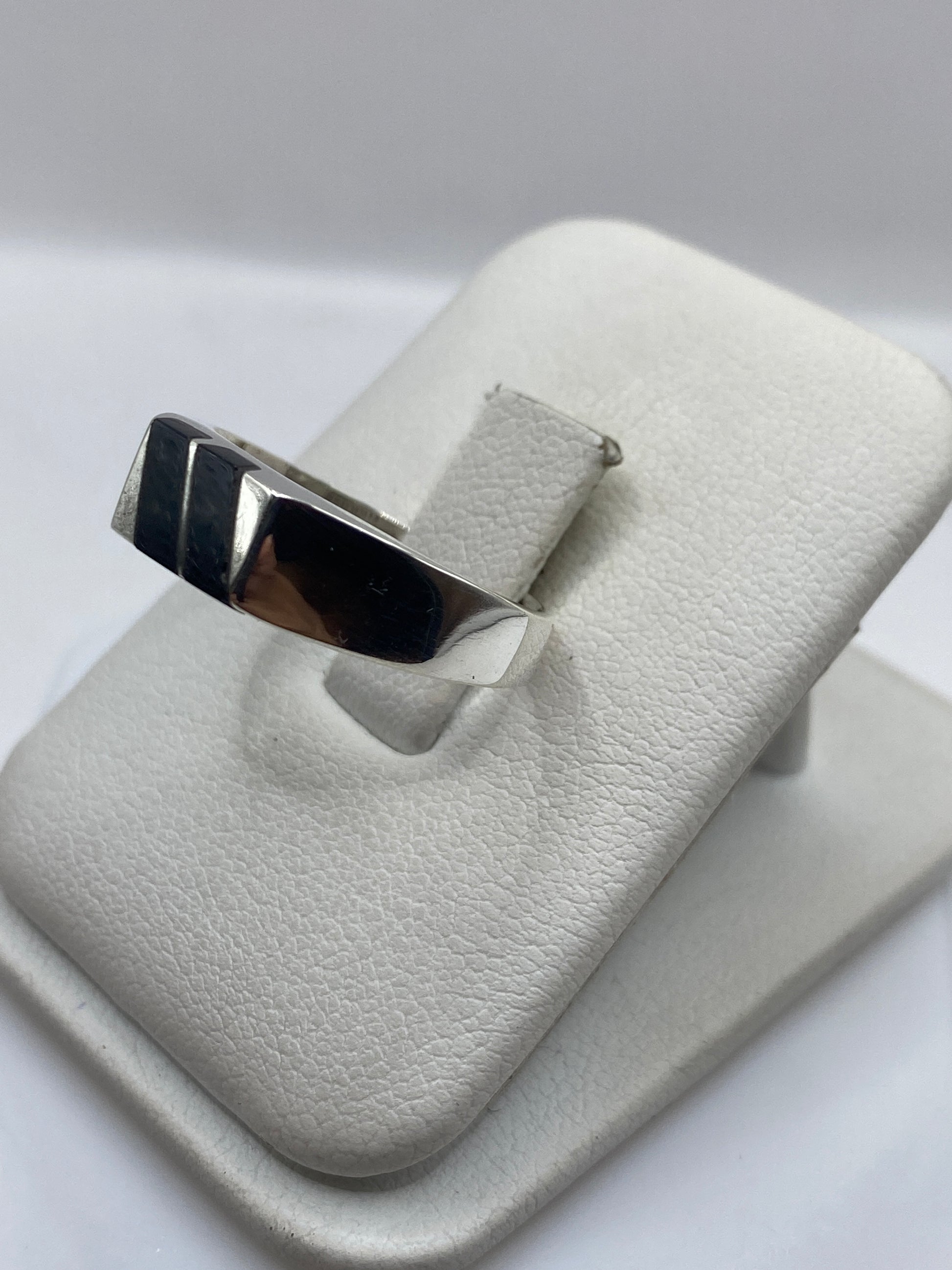 Detalle lateral del anillo mostrando la banda de plata y el acabado del onix