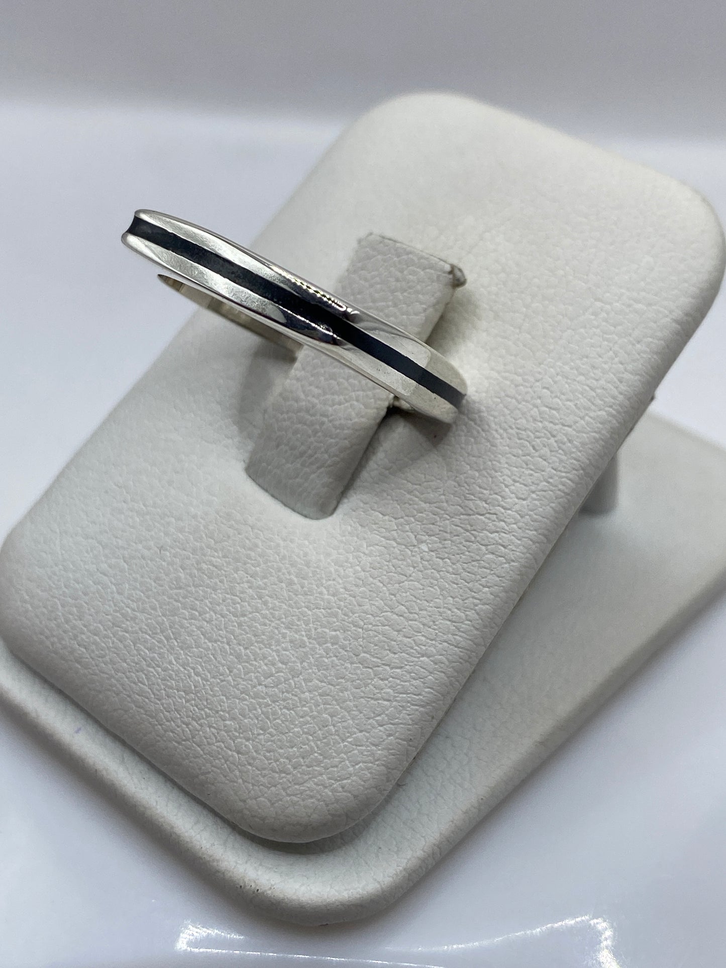Vista lateral del anillo minimalista en plata con banda recta negra