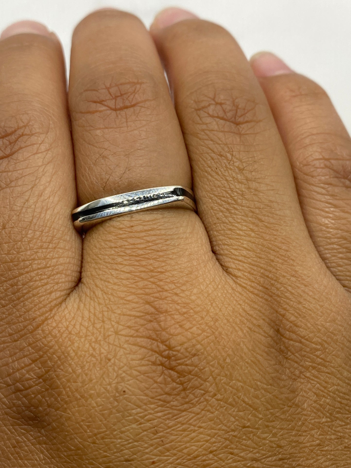 Anillo de plata en dedo masculino mostrando el sello de ónix negro en uso diario
