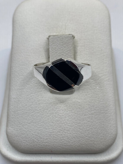 Anillo de plata con ónix negro en forma de solitario moderno sobre base de piel blanca