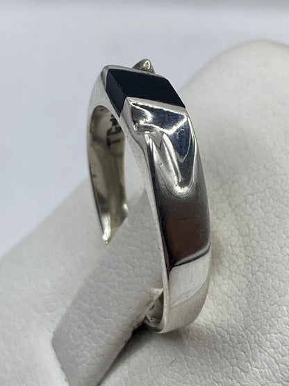 Anillo de ónix negro en la mano, vista de frente mostrando presencia discreta