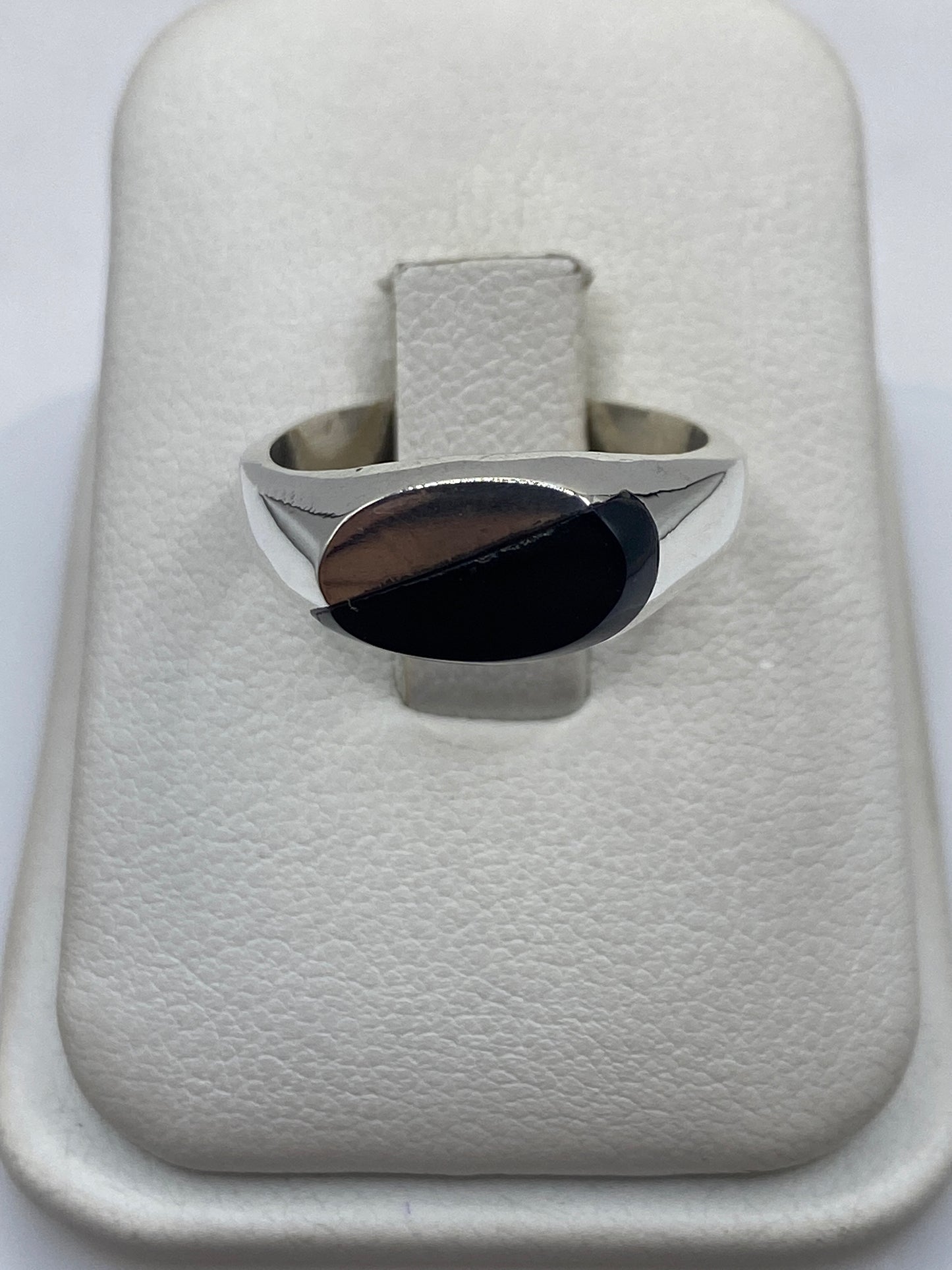 Anillo de plata .925 con ónix negro sólido, vista frontal sobre cojín blanco