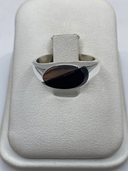 Anillo de plata .925 con ónix negro sólido, vista frontal sobre cojín blanco
