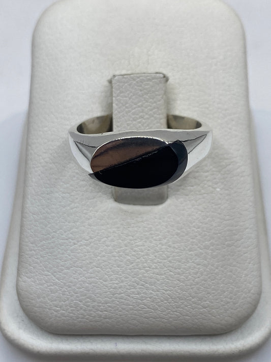 Anillo de plata .925 con ónix negro sólido, vista frontal sobre cojín blanco