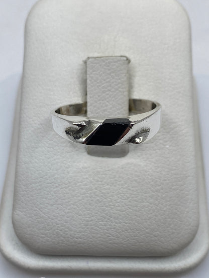 Anillo de plata .925 con ónix negro rectangular en mano de persona con piel clara