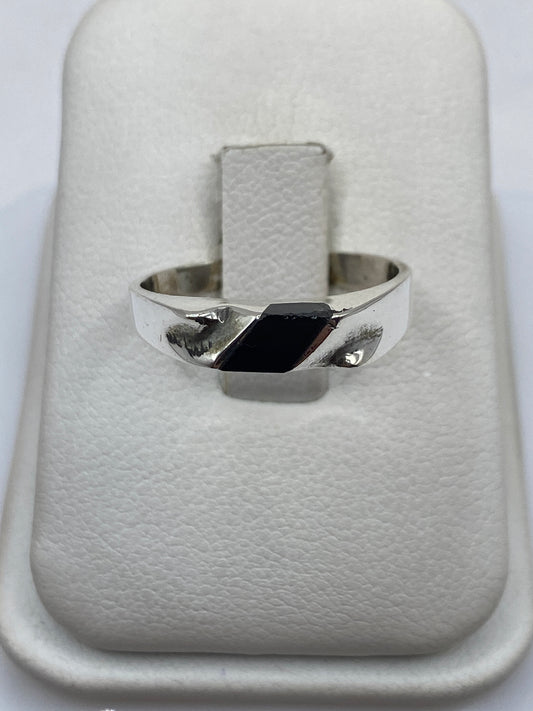 Anillo de plata .925 con ónix negro rectangular en mano de persona con piel clara