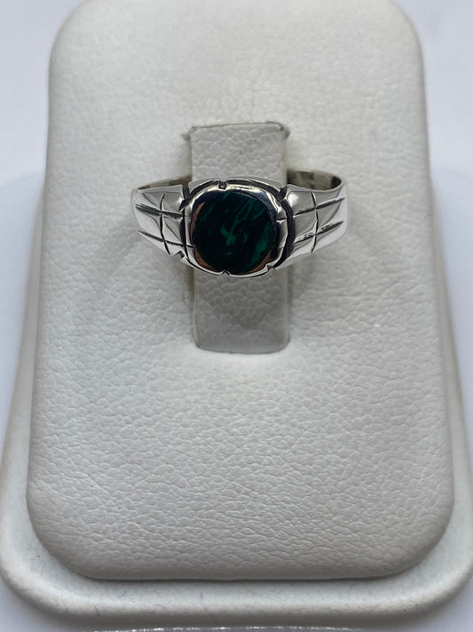 Anillo de plata con malaquita verde en dedo de mujer sobre fondo blanco