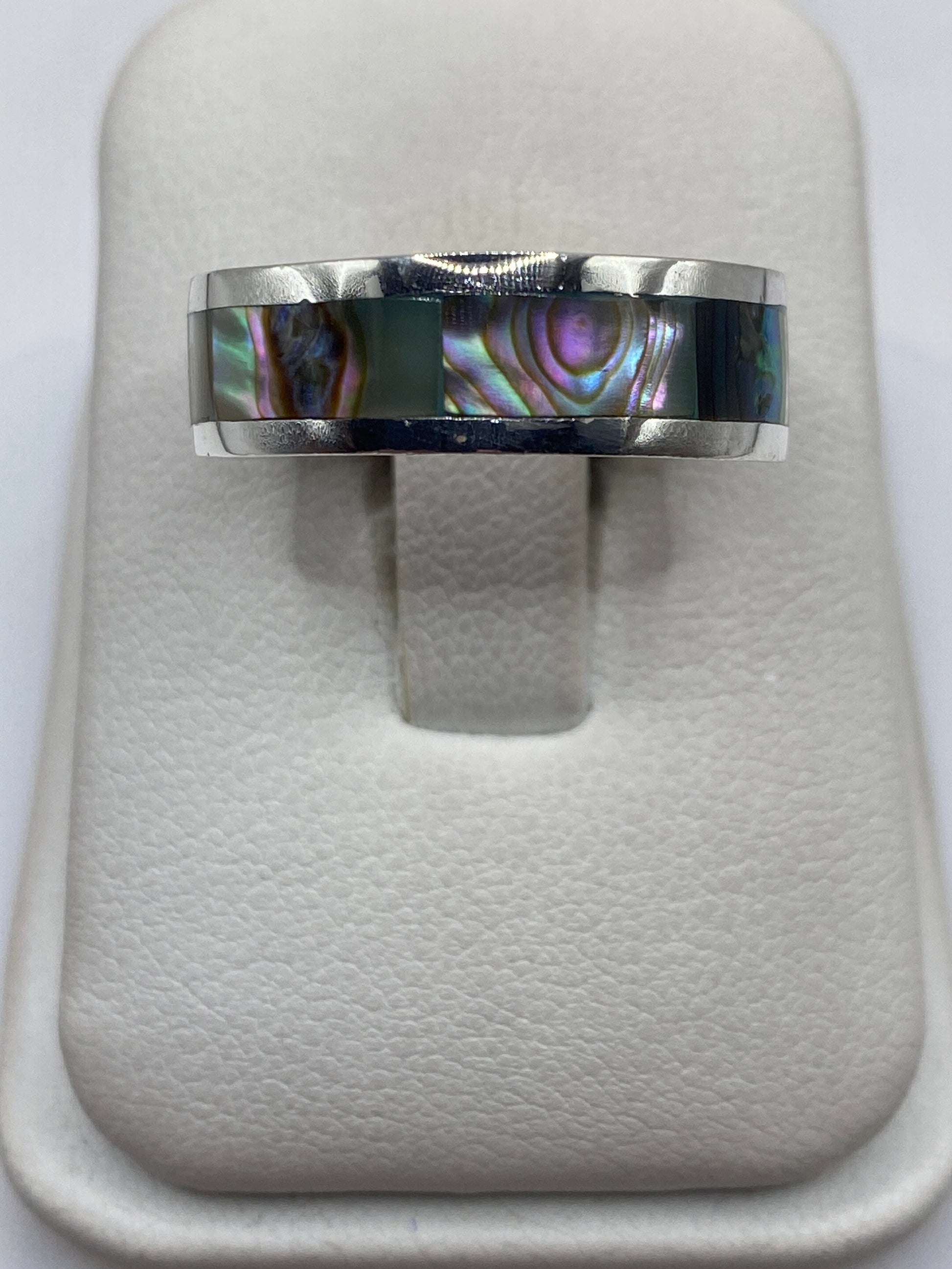 Anillo de plata .925 con incrustación central, vista frontal sobre soporte de terciopelo blanco