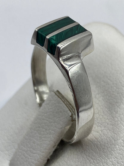 Anillo de plata con malaquita puesto en mano, vista lateral