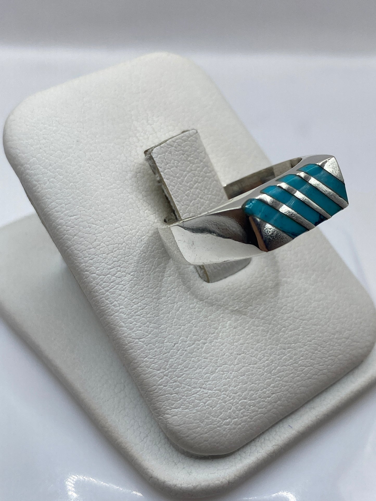 Anillo de turquesa y plata colocado en la mano mostrando el color azul cielo y las bandas de metal