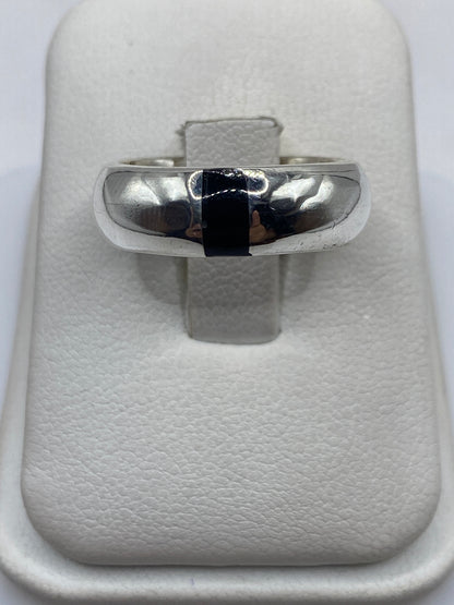 Anillo de plata con ónix negro pulido, banda ancha, en dedo de hombre