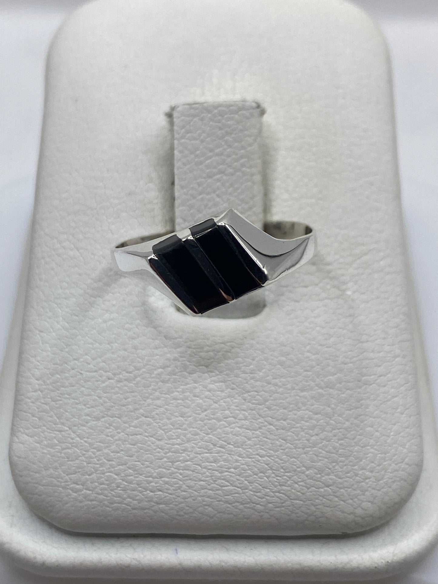 Anillo de plata con dos rectángulos de ónix negro pulido en bandeja blanca de presentación