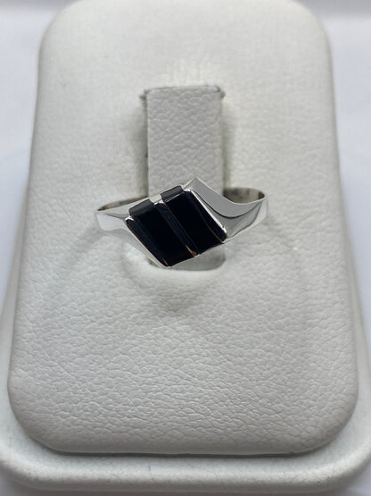 Anillo de plata con dos rectángulos de ónix negro pulido en bandeja blanca de presentación