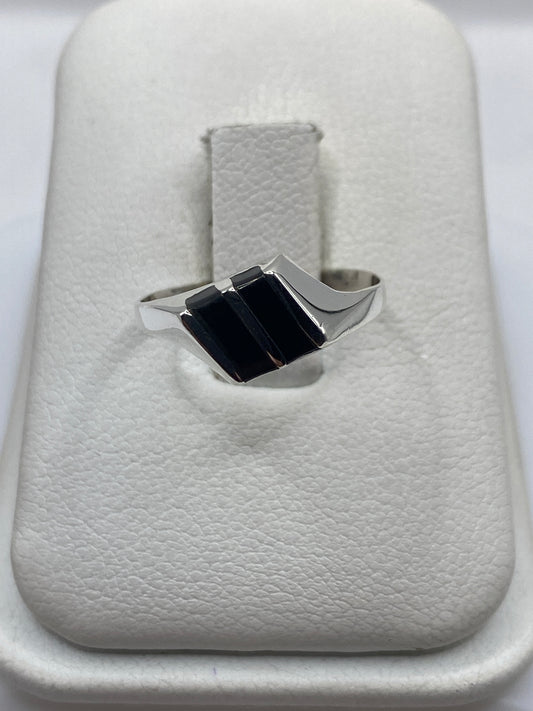Anillo de plata con dos rectángulos de ónix negro pulido en bandeja blanca de presentación