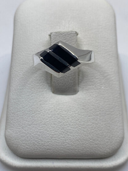 Anillo de plata .925 con dos rectángulos de ónix negro en la mano de una persona