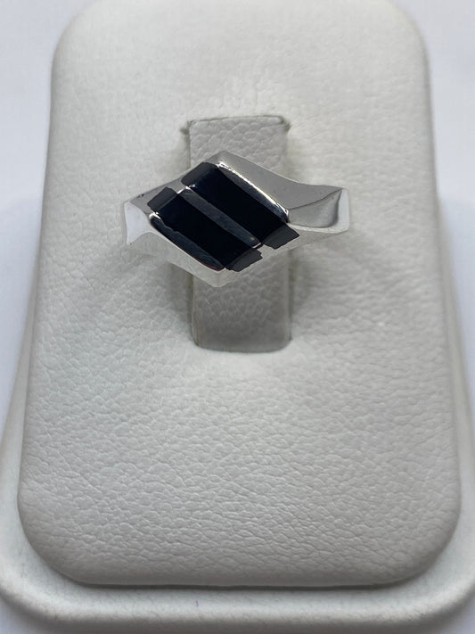 Anillo de plata .925 con dos rectángulos de ónix negro en la mano de una persona