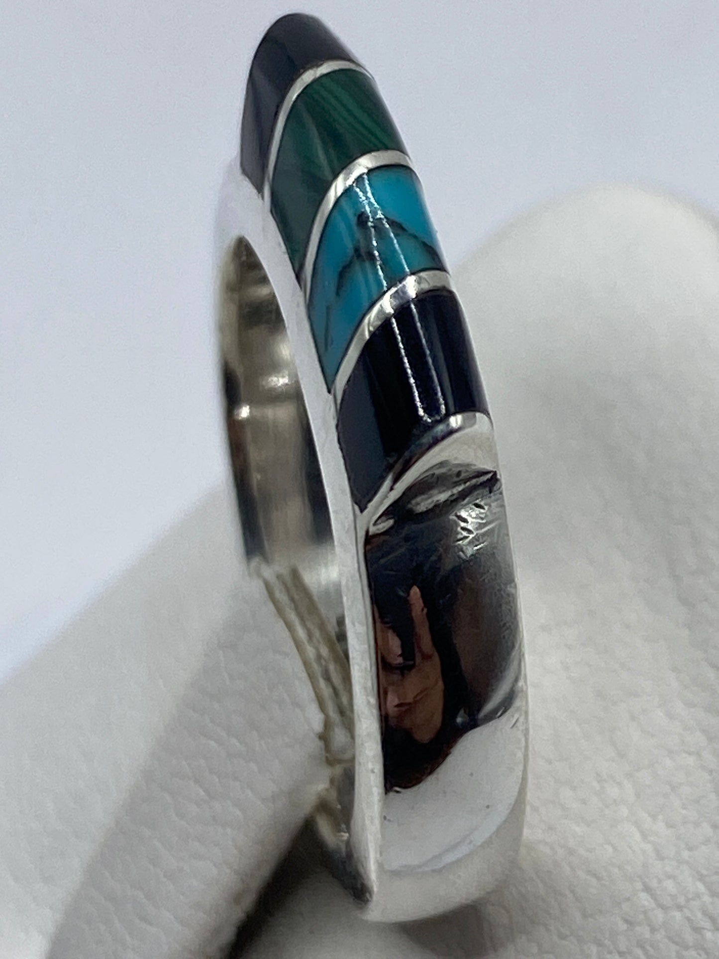 Anillo de malaquita en dedo masculino mostrando el diseño unisex de bandas anchas