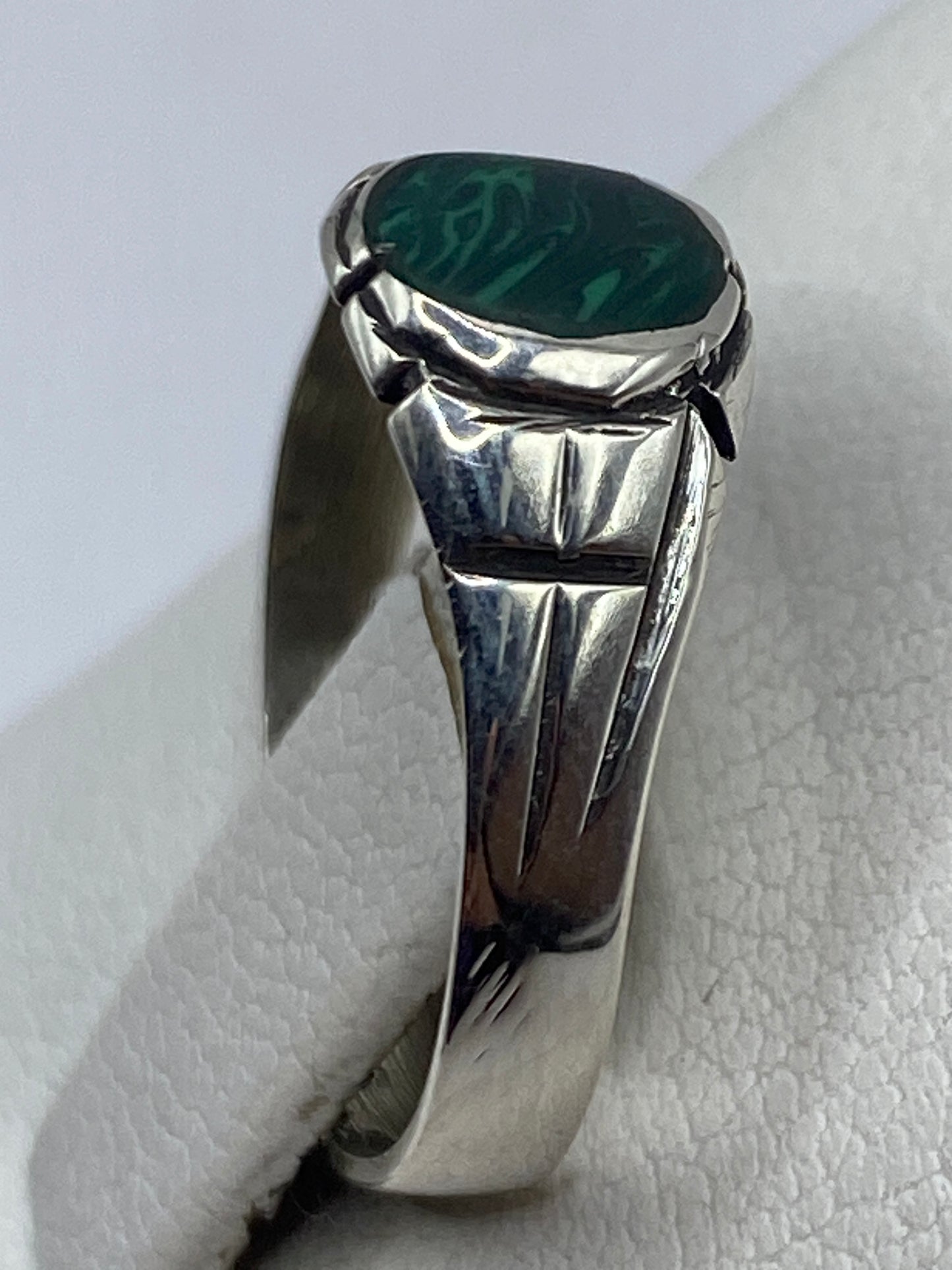 Anillo minimalista de plata en dedo mostrando el verde profundo de la malaquita
