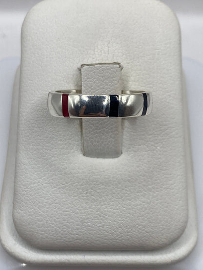 Anillo de plata con ónix negro en banda geométrica, sobre almohada blanca